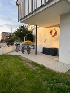 a patio with a table and chairs and a balcony at Spatzennest am Bodensee in Bermatingen +1 photo