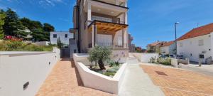a house with white walls and a balcony at Apartman Lovor in Primošten