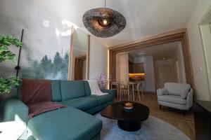 a living room with a blue couch and a table at SkyHill Jahorina Poljice Gondola in Jahorina