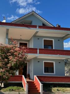a white house with red stairs and a tree at 3 Roots Villa in Krujë