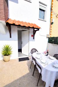 a table with plates on it in front of a building at Acogedor apartamento de 2 habitaciones, parking & conford in El Astillero
