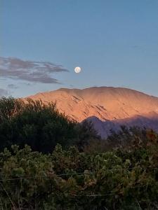 a view of a mountain with the moon in the sky at Hostel Portal del Sol in Fiambalá