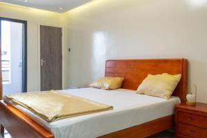 a bedroom with a large bed with a wooden headboard at Résidence Madior D2 in Dakar