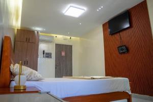 a bedroom with a bed and a tv on the wall at Résidence Madior D2 in Dakar