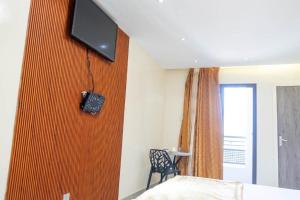 a room with a bed and a television on a wall at Résidence Madior D2 in Dakar