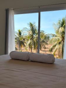 a bed with a pillow in a room with palm trees at Bamboo in El Paredón Buena Vista +9 photos
