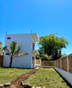 a white house with a fence and a yard at Bamboo in El Paredón Buena Vista