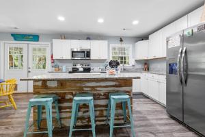 a kitchen with white cabinets and blue stools at Sailors Delight in Beaufort