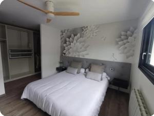 a bedroom with a white bed and a ceiling fan at Maison cosy in Grésy-sur-Aix +6 photos