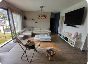 a living room with a couch and a tv at Maison cosy in Grésy-sur-Aix