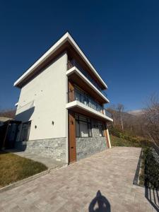a large white building with a wooden door at Mountain sight Villa in Sheki