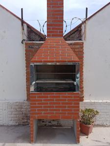 a brick oven sitting on the side of a building at Cabañas Brisa's in Santa Vitória do Palmar
