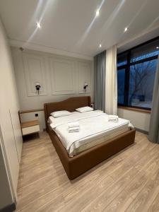 a bedroom with a bed and a large window at Mountain sight Villa in Sheki