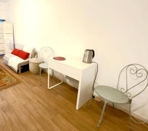 a white table and a chair in a room at MataDoora in Nîmes