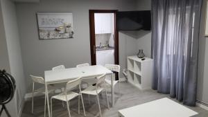 a white dining room with a white table and chairs at PASEO CASCO ANTIGUo in Lugo