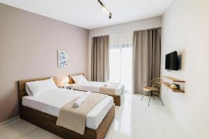 a hotel room with two beds and a tv at Sithonian Sunset Luxury Apartments in Skála Nikíta