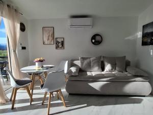 a living room with a couch and a table and chairs at Lake View Terrace Apartment Dapcevic in Vranjina