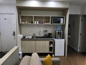 a living room with a couch and a kitchen at Flat colado a praia de Boa Viagem in Recife