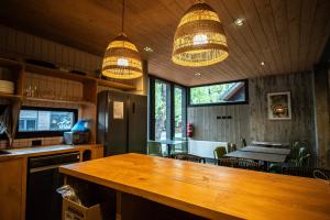 a kitchen with a wooden table and some lights at Roble Viejo Lodge in Las Trancas