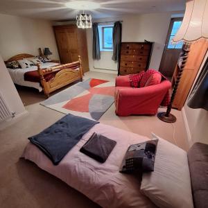 a bedroom with a bed and a chair in a room at Parciau barn in Clyro