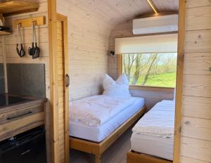 two beds in a small room with a window at Gut Osterhausen in Butjadingen