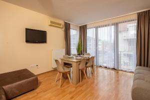 a living room with a table and chairs and a television at Fritz Holiday in Siófok