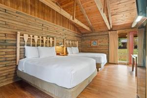two beds in a room with wooden walls at Lucky Trout Lodge in Heber Springs +34 photos