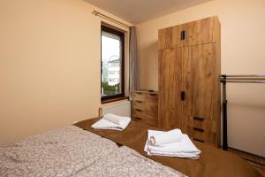 a bedroom with a bed and a dresser and a window at Fritz Holiday in Siófok +16 photos