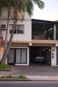 a white house with a car in the garage at Doña Minina in Posadas