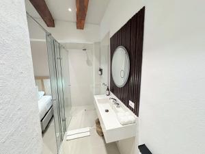 a white bathroom with a sink and a mirror at Casa Helena Getsemaní in Cartagena de Indias
