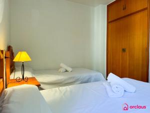 a bedroom with two beds and a lamp and a door at Poble Mar 8 in Oropesa del Mar