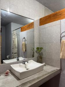 a bathroom with a white sink and a mirror at Hotel SPA Campestre Los Adobes in Taxco de Alarcón