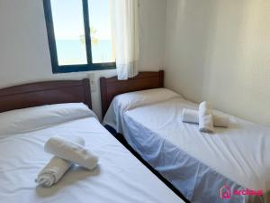 two beds in a room with white sheets at Poble Mar 8 in Oropesa del Mar