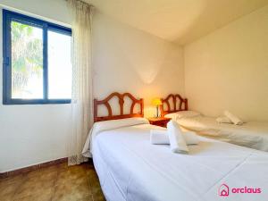 two beds in a room with a window at Poble Mar 8 in Oropesa del Mar