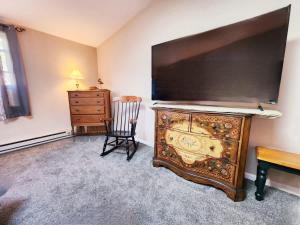 a room with a dresser and a chair and a television at Oneida Lakeside Retreat in Bridgeport