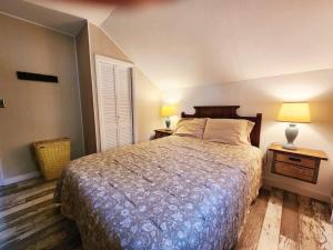 a bedroom with a bed and two lamps on two tables at Oneida Lakeside Retreat in Bridgeport