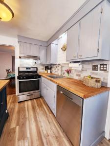 a kitchen with white cabinets and a wooden counter top at Oneida Lakeside Retreat in Bridgeport