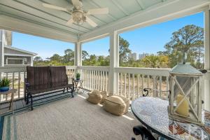 a screened in porch with a table and a chair at Salt & Pine in Pensacola
