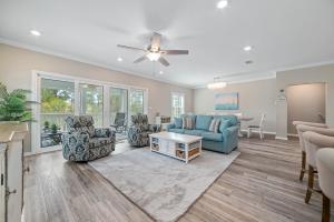 a living room with a blue couch and chairs at Salt & Pine in Pensacola +53 photos