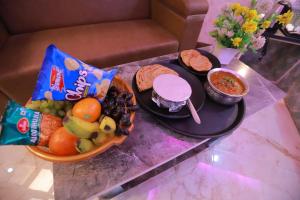 a table with a plate of food and a bowl of fruit at Hotel Radha Rani palace in Ayodhya