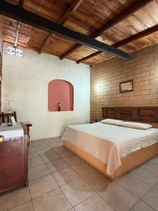 a bedroom with a large bed in a brick wall at Hotel SPA Campestre Los Adobes in Taxco de Alarcón