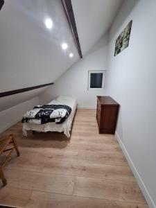 a bedroom with a bed and a wooden floor at Le GIGI in Antony