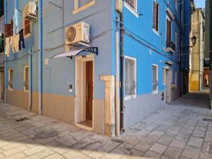 a blue building with a door on a street at CHIOGGIA VENICE APARTMENT in Chioggia