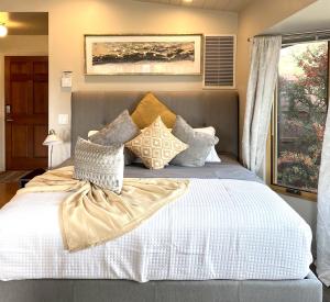 a bedroom with a bed with white sheets and pillows at Perfect Couples Getaway Private Hot Tub Panoramic Red Rock Views in Sedona