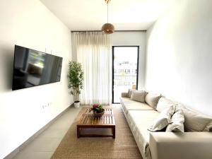 a living room with a couch and a tv at Beachfront Paradise - Huge Pool, Ocean View & Surf in Cabarete