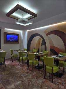 a dining room with tables and chairs and a painting on the wall at B&B Vanity in Tropea