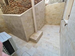 a bathroom with a shower with a stone wall at VENEZIA Playa in Chioggia