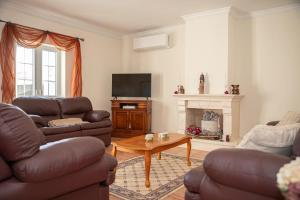 a living room with two couches and a tv at A Casa do Olival in Mealhada
