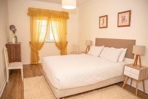 a bedroom with a large white bed and a window at A Casa do Olival in Mealhada +17 photos