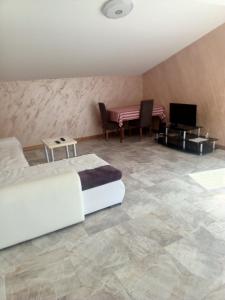 a bedroom with a bed and a table with a television at Super Vila in Jajinci